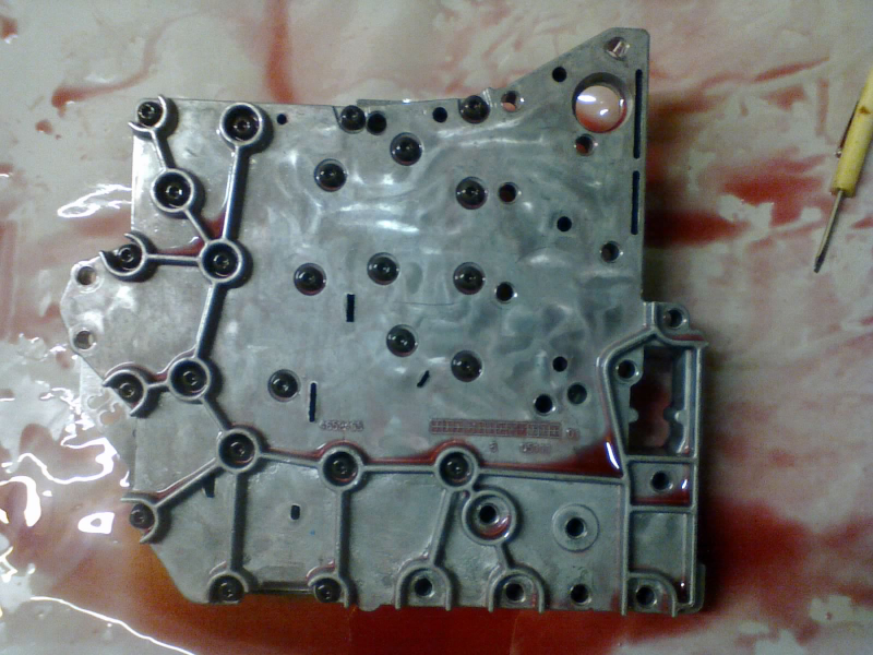 ...and lay them both right on top of the main valve body. These torx bolts clamp the transfer plate to the main valve body, sandwiching the separator plate in-between and trapping the check-balls inside their passages.